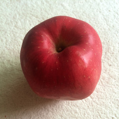 red apple on white carpet