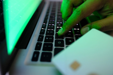 hacker hand stelling data from laptop, closeup 