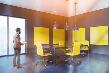 Businessman in gray and yellow meeting room