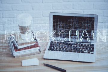 Double exposure of blockchain theme hologram and table with computer background. Concept of bitcoin crypto currency.