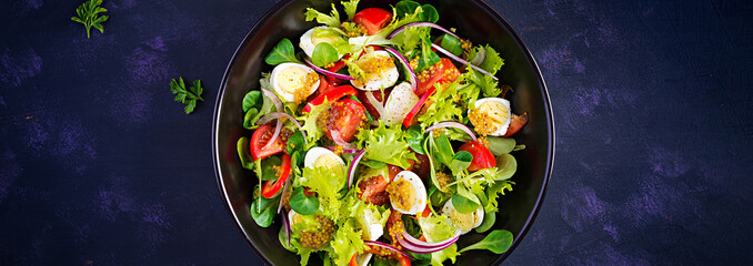 Fresh salad with vegetables tomatoes, red onions, lettuce and quail eggs. Healthy food and diet concept. Vegetarian food. Top view, banner