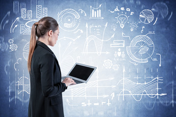Woman with laptop looking at business plan
