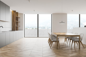 White kitchen interior with balcony and table