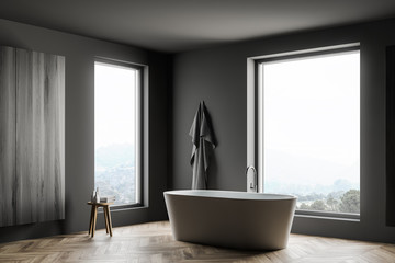 Gray bathroom corner with tub and cabinet