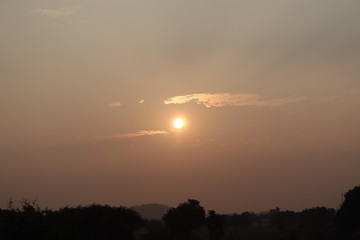 landscape on sunrise with sun and sunlight from yellow clouds in blue sky