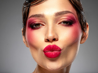 Emotional girl is kissing. Excited woman. Beautiful sexy girl with bright eye makeup. Sensual young...