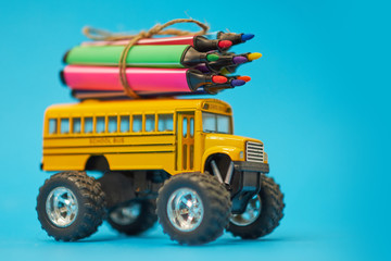Naklejka premium Yellow School bus and felt-tip pens on the roof, back to school concept, yellow background, copy space. education. isolated on blue background