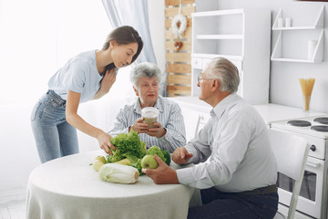 Family in a kitchen. Grandparents with granddaughter. Family made a salad