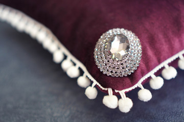 Fragment of a decorative pillow with rhinestones in interior