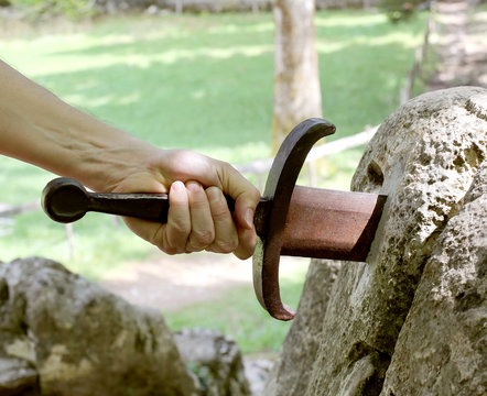 Excalibur Sword in the stone nad the hand of a man