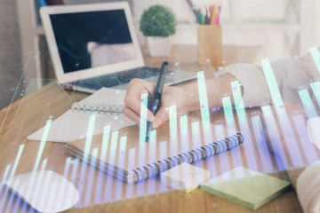 Financial charts displayed on woman's hand taking notes background. Concept of research. Double exposure