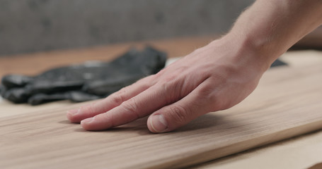 man hand touches black walnut board