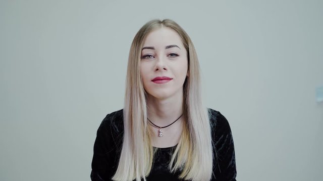 Portrait of a blonde woman with bright lips. Beautiful girl looking at camera and smiling isolated in studio.