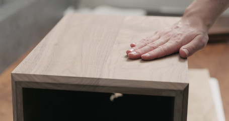 man hand touches black walnut storage box