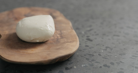 Fototapeta na wymiar fresh mozzarella cheese on olive wood board