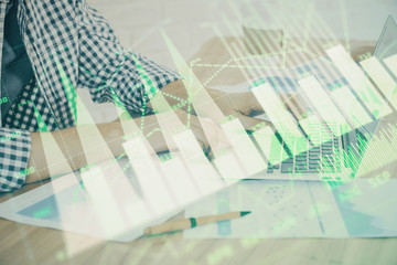 Multi exposure of stock market chart with man working on computer on background. Concept of financial analysis.