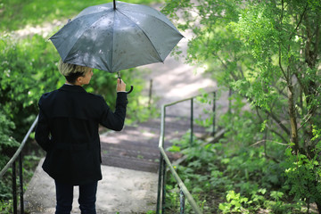 Spring rainy weather and a young man with an umbrella