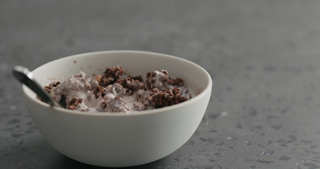 man hand mixing chocolate granola with yogurt