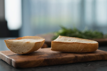Toasted half of ciabatta for sandwich on olive board