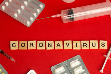 Coronavirus 2019-ncov epidemic concept. Coronavirus on a red background with pills, syringes and antiviral medicines and drugs. Vaccine and virus treatment