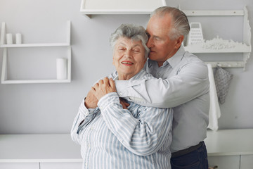Old couple in a room. Grandparents at home. Woman in a whire whirt
