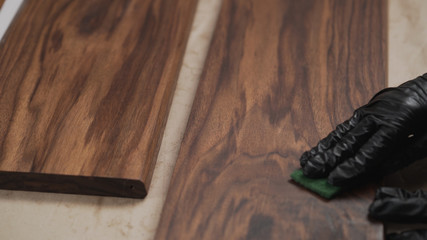 man sanding black walnut after oil application with abrasive pad © GCapture