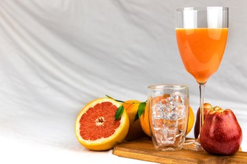 Fresh juice of red grapefruit with apples on white cloth. Diet drink. Homemade juice. Glass with drink.