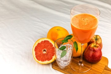 Fresh juice of red grapefruit with apples on white cloth. Diet drink. Homemade juice. Glass with drink.