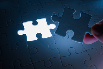 Missing piece of jigsaw puzzle with light glow, business concept for completing the final puzzle...