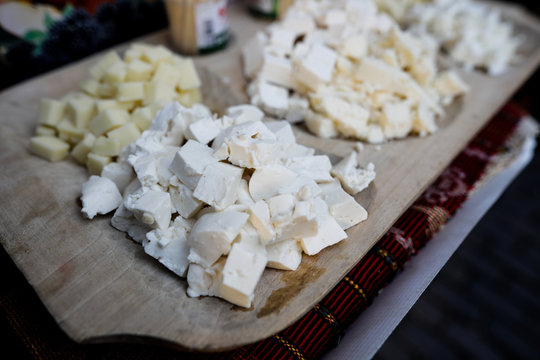 Shallow depth of field (selective focus) image with white cheese on a wooden plate.