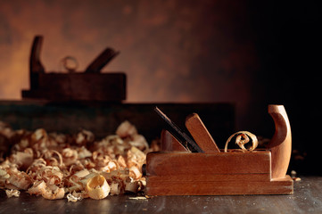 Old wooden jointer and shaving on wooden table.