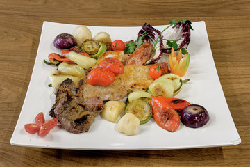 Food on a white plate served on the wooden table, top view.