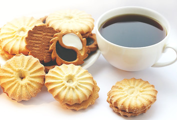 Beautifully laid out cookies on a saucer. White cup with black tea. Tea ceremony.