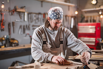 Carpenter working on a old wood in a retro vintage workshop.