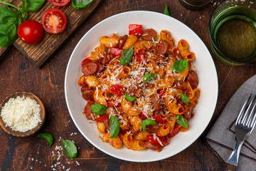 Spicy sausages marinara pasta in white bowl