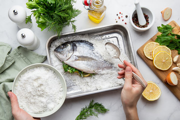 Preparing salt-baked dorada fish
