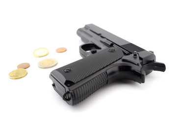 Gun and euro coins on a white background