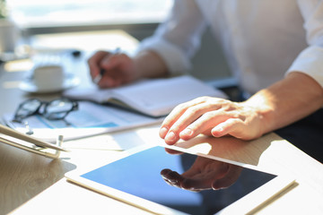 Businessman using his tablet in the office.