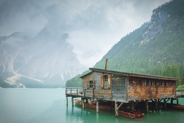 Rainy landscape of Italian mountain lake. Wooden shelter at Lago di Braies. 
