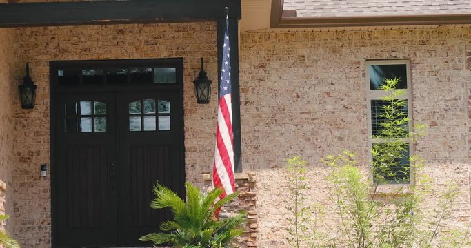 American flag flying proudly on the front of a nice upscale house