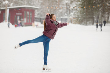 Girl skater at an outdoor rink in winter © olgasparrow