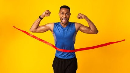 Happy black man celebrating success breaking finish rope