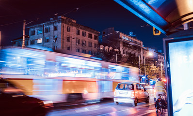 Night scene of tram in traffic with lighttrail motion blur