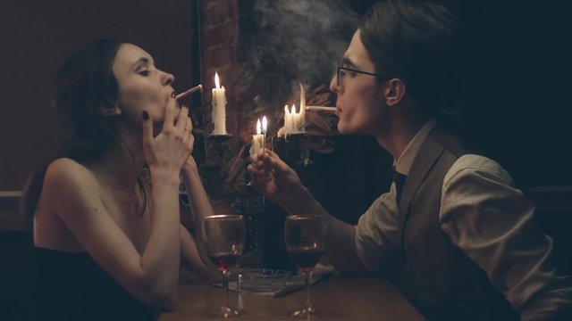 Couple at romantic dinner with candles and wine, shallow depth of field, slow motion