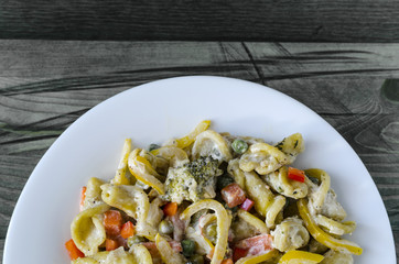 pasta with vegetables and cheese on a white plate top view homemade food