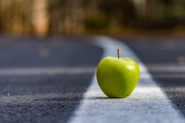 Conceptual landscape with a green apple on the leading lines of the road,Sfanta Ana, Romania