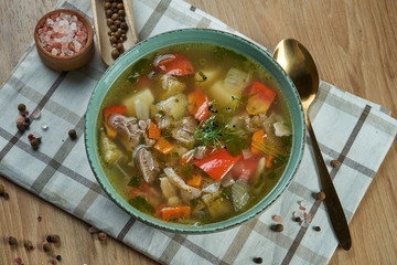 Shurpa - a traditional, thick and nutritious soup from the Caucasus. Appetizing lamb soup with tomatoes, peppers, onions and potatoes in a blue bowl. Close up