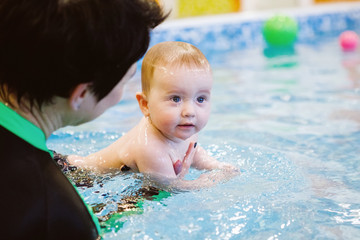 Female and child swim in water pool.