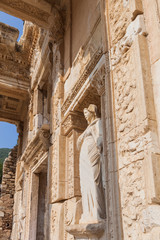 Celsus library and sculpture in Ephesus ancient city ruins on cloudy sky in Izmir, Turkey.