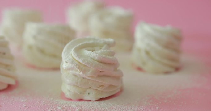 Sprinkling powder on the sweet dessert cakes, pink background
